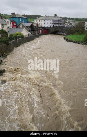 Aberaeron, UK. 13. Oktober 2018. Ein Bild der Verwüstung in Aberaeron Hafen auf der West Wales Küste am Nachmittag als schwerer Regen und starkem Wind vom Sturm Callum weiterhin Chaos zu verursachen. Flut, Wasser aus dem Fluss Aeron mit Bäumen und grossen Niederlassungen Crash in Boote es Schäden an vielen und völlig versinken. Credit: Anthony Pugh/Alamy leben Nachrichten Stockfoto