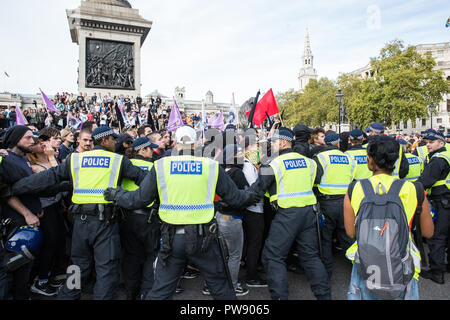 London, Großbritannien. 13. Oktober, 2018. Polizisten enthalten, antifaschistischen Gruppen, darunter auch viele Frauen aus der Feministisch antifaschistischen Versammlung marschieren durch den Trafalgar Square im Protest gegen eine Demonstration von der Demokratischen Fußball Jungs Alliance (DFLA). Anti-rassistische Gruppen hielt auch eine Einheit Demonstration mit der DFLA Demonstration zusammenfällt. Der Metropolitan Police auferlegten Bedingungen auf den Demonstrationen zu "ernste Störung und ernste Störungen für das Leben der Gemeinschaft" zu verhindern. Credit: Mark Kerrison/Alamy leben Nachrichten Stockfoto