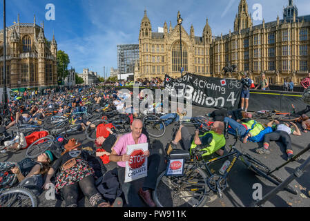 London, Großbritannien. 13. Oktober 2018. Leute, einschließlich Donnachadh McCarthy (in rosa Hemd) der Töten Radfahrer nehmen an einem 10-minütigen sterben - in außerhalb des Parlaments am Ende der Trauerzug der Radfahrer hinter einer von Pferden gezogenen Leichenwagen das Versagen der Regierungen von allen großen Parteien zu markieren umfassende Maßnahmen zum sicheren Radfahren. Töten Radfahrer Anruf für £ 3 Milliarden jährlich in einem nationalen geschützt Radwegenetz und für dringende Maßnahmen der giftige Luftverschmutzung aus Diesel und Benzin Fahrzeuge, die Zehntausende Menschen jedes Jahr tötet zu reduzieren investiert werden, und Stockfoto