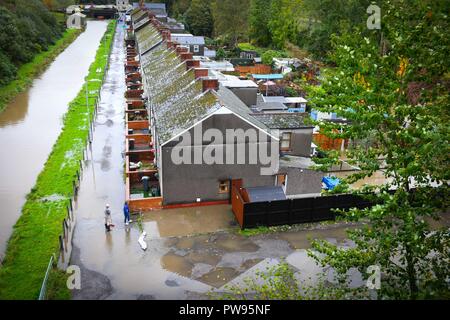 Samstag, 13. Oktober 2018. Tonna, South Wales, UK. Überschwemmung bewirkt die Dörfer von Aberdulais und Tonna in der Neath Valley in South Wales nach Sturm Callum starker Regen und Wind in den Bereich des Flusses Neath brachte Bersten zu erreichen. Abgebildet sind die Bewohner von Canal Seite, weckte zu finden, ihre Eigenschaften und Gärten überflutet. Zwei Bewohner stehen außerhalb der überfluteten Häuser. Credit: Robert Melen/Alamy leben Nachrichten Stockfoto