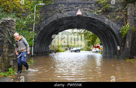 Samstag, 13. Oktober 2018. Tonna, South Wales, UK. Überschwemmung bewirkt die Dörfer von Aberdulais und Tonna in der Neath Valley nach Sturm Callum starker Regen und Wind in den Bereich des Flusses Neath brachte Bersten zu erreichen. Ein Mann geht durch das Hochwasser in Tonna. Robert Melen/Alamy Leben Nachrichten. Stockfoto