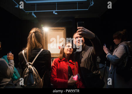 London, Großbritannien. 14. Oktober 2018. Die Besucher nehmen selfies vor banksys "Liebe im bin", die in der Öffentlichkeit bei Sothebys in New Bond Street in London. Die Kunstwerke, die früher als "Das Mädchen mit einem Ballon" bekannt wurde geschreddert Momente nach dem Zuschlag und der Hammer fiel bei Auktion an einen ausländischen Käufer am 5. Oktober Credit: Amer ghazzal/Alamy Live News Credit: Amer ghazzal/Alamy leben Nachrichten Stockfoto