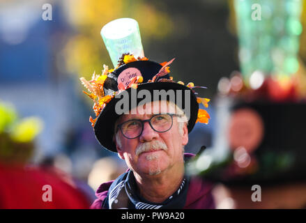 Neustadt, Deutschland. 14 Okt, 2018. Ein Zug Mitglied trägt ein Glas Wein auf seinem Kopf. Nach Angaben der Veranstalter rund 100 Zugnummern und über 100.000 Zuschauer werden nehmen Sie teil an Deutschlands größte Winzer Parade in Neustadt an der Weinstrass. Foto: Andreas Arnold/dpa Quelle: dpa Picture alliance/Alamy leben Nachrichten Stockfoto