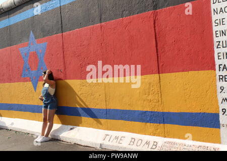 Mädchen an der Berliner Mauer East Side Gallery Bild der Deutschen und der israelischen Flagge Stockfoto
