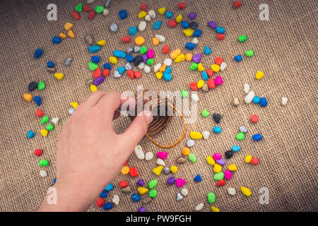 Korb mit bunten Steinen verschüttet Hintergrund Stockfoto