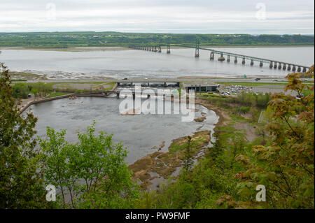 Nebenfluss zum St. Lawrence River, die Montmorency Fluss verbindet es flussabwärts von Montmorency Falls. Île d'Orléans und eine Hängebrücke in den Rücken. Stockfoto