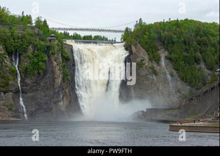 Die Kaskadierung Gewässer des Montmorency fällt in einen Abgrund zu stürzen. Eine Hängebrücke überspannt die Crest. Quebec, Kanada Stockfoto