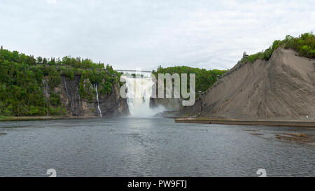 Die Kaskadierung Gewässer des Montmorency fällt in einen Abgrund zu stürzen. Eine Hängebrücke überspannt die Crest. Quebec, Kanada Stockfoto