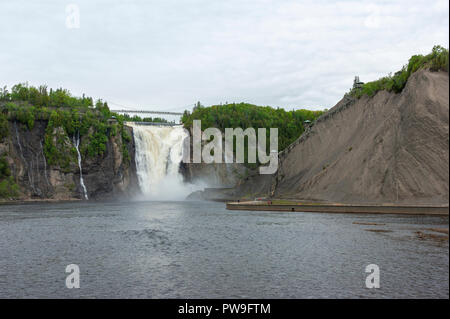 Die Kaskadierung Gewässer des Montmorency fällt in einen Abgrund zu stürzen. Eine Hängebrücke überspannt die Crest. Quebec, Kanada Stockfoto