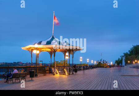 Die Esplanade auf der Terrasse Dufferin, mit Bänken, Strassenlaternen, Leitplanken und Pavillons. Die Menschen genießen den Blick über die St. Lawrence River bei Einbruch der Dunkelheit. Stockfoto