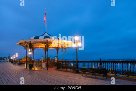 Die Esplanade auf der Terrasse Dufferin, mit Bänken, Strassenlaternen, Leitplanken und Pavillons. Die Menschen genießen den Blick über die St. Lawrence River bei Einbruch der Dunkelheit. Stockfoto