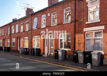 Reihe von Mülltonnen außerhalb Reihenhäuser zur Abholung bereit in Crewe, Cheshire Vereinigtes Königreich Stockfoto