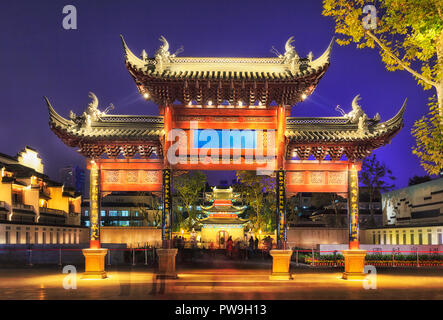 Traditionellen alten bewaldeten Tore vor Konfuzius Tempel- und Bildungszentrum in Nanjing, China, bei Sonnenuntergang mit Beleuchtung durch Straßenlaternen. Stockfoto