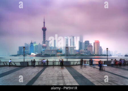 China Shanghai Pudong CBD Sonnenuntergang Blick über den Fluss beleuchteten Wolkenkratzer und Türmen, die durch Luftverschmutzung smog bedeckt Stockfoto