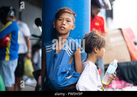 Eine junge Filipino junge blickt in die Kamera, der Innenstadt von Cebu City, Philippinen