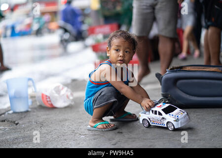 Junge philippinische Kinder spielen mit einem spielzeugauto auf Straße, Bürgersteig, Cebu City, Philippinen