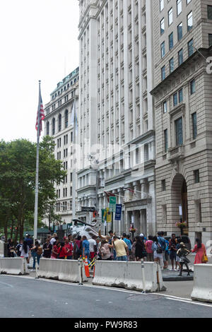 NEW YORK, NEW YORK - 19. August 2018: Touristen versuchen in der Nähe der Ladestation Stier Skulptur im unteren Manhattans Finanzdistrikt zu erhalten Stockfoto