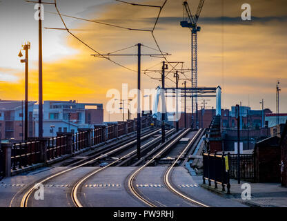 Straßenbahn- und Straßenbahnlinien im Zentrum von Manchester, UK, mit Sonne und Wolken Stockfoto