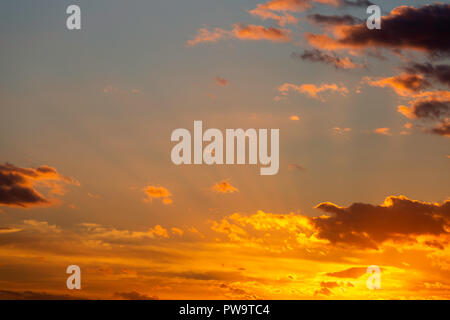 Sonnenstrahlen, die manchmal als Gott strahlen, inmitten Orange Wolken bei Sonnenuntergang im September bekannt. Von Oare Sümpfe Naturschutzgebiet, Kent, Großbritannien. Stockfoto