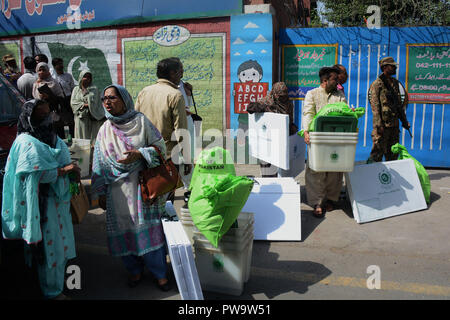 Wahlkommission Pakistans (ECP) Personal ist die Wahlurnen und andere Elemente zu einem Wahllokal am Regierung Islamia High School vor den Wahlen wurde unter der Aufsicht von Pak Armee in Lahore am 13. Oktober 2018. Pak Armee und Pakistanischen Wahl präsidierenden Beamten tragen Wahl Materialien für eine Nachwahl nach Erhalt von der Verteilung von Punkt in Lahore, über 100 Kandidaten wetteifern für 35 National Assembly und provinzversammlung Sitze in der Wahl für den 14. Oktober vorgesehen. (Foto von Rana Sajid Hussain/Pacific Press) Stockfoto