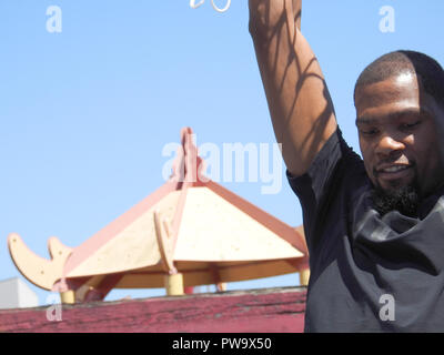 Golden State Warriors Spieler Kevin Durant hängt von der Felge in einem neuen Basketballplatz am Lincoln Square Park in Oakland Chinatown am 18. Mai 2017. Durant, zwei - Zeit NBA Finals MVP, spendete das Gericht durch seine Kevin Durant Charity Foundation. Stockfoto