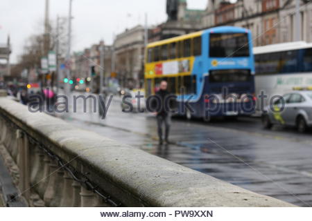 Menschen und Busse auf der O'Connell Bridge in Dublin, Irland, an einem regnerischen Tag im April Stockfoto