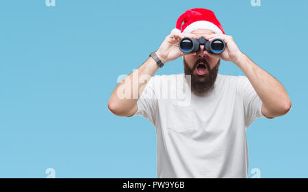 Junge kaukasier hipster Mann mit Mütze, obwohl Fernglas über isolierte Hintergrund im Schock Angst mit einer Überraschung Gesicht, Angst und Stockfoto