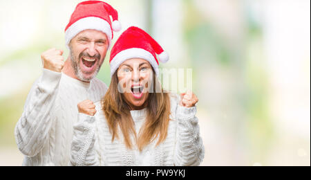 Mittleres Alter spanischer Paar tragen Mütze über isolierte Hintergrund feiern überrascht und für den Erfolg mit erhobenen Armen und offenen Augen überrascht. Stockfoto