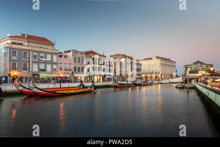 Aveiro, Portugal. Juli 28, 2018. Den zentralen Kanal in Aveiro, mit mehreren Moliceiros verankert und Häuser im Jugendstil im Hintergrund in der Abenddämmerung. Zentrum von Stockfoto