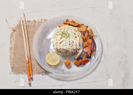 Hausgemachte Nudeln und Curry Thai Stil mit Karotten, shitake und Huhn auf dem Teller serviert. Stockfoto