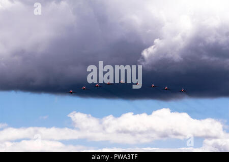 Rote Pfeile auf der Farnborough Air Show aus schwarzen Wolken fliegen Stockfoto