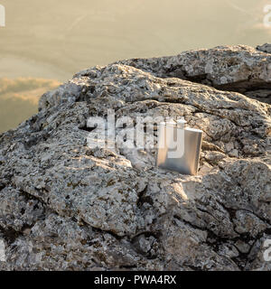 Wunderschön sonnigen metallische Alkohol Kolben auf einem kontrastreichen Rock Stockfoto