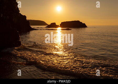 Sonnenuntergang über die Cardigan Bay gesehen von Tresaith, Ceredigion. Blick in Richtung der Landspitze von Aberpoth Stockfoto