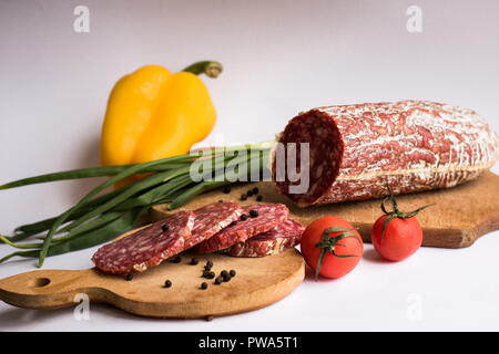 Wurst Stücke mit gelbe Paprika und Kartoffeln auf weißem Hintergrund Stockfoto