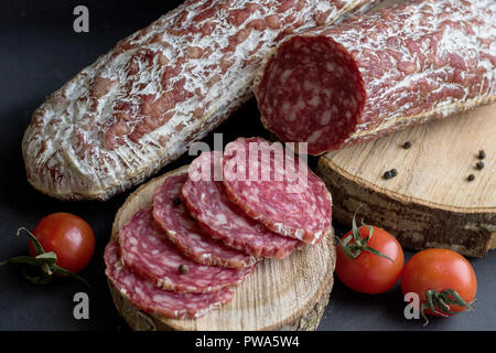 Wurst mit Brot und Kartoffeln auf schwarzem Hintergrund Stockfoto