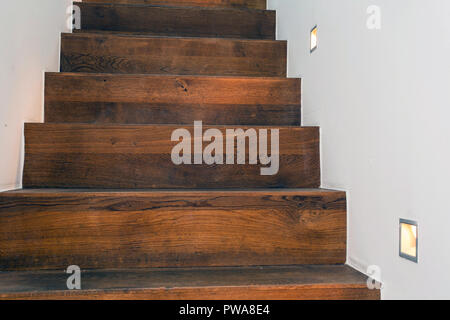 Holz Treppen bei Nacht mit LED-Licht in die weiße Wand modernes Design Stockfoto