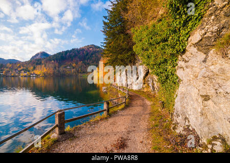 Wanderweg mit einem Zaun entlang Lake Wolfgangsee in den österreichischen Alpen. Weg von Fuerberg nach St. Gilgen, Österreich Stockfoto