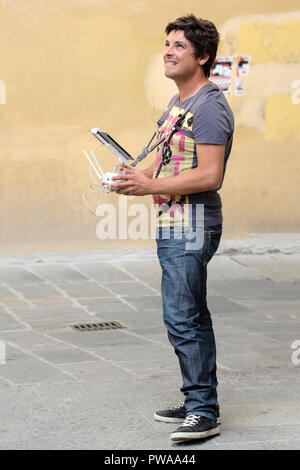Junger Mann die Erprobung einer Drohne über dem Ospedale del Ceppo in der Piazza Giovanni, Altstadt von Pistoia, Toskana, Italien, Europa, Stockfoto