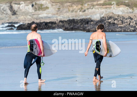 Zwei Surfer zu Fuß vom Meer ihre surfbretter auf Fistral Beach in Newquay in Cornwall. Stockfoto