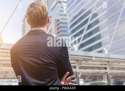 Rückansicht des kaukasischen Geschäftsmann im Büro gebäude Hintergrund für Business Vision Concept suchen Stockfoto