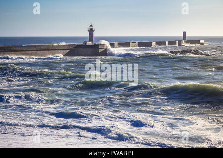 Wellen von einer rauen Atlantik Absturz auf Porto's Pier mit Leuchtturm Farolim de Tavira, Portugal Stockfoto