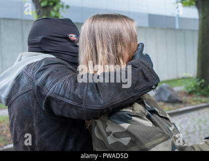 Man Angriffe einer Frau tagsüber hinter ihr zu berauben. Stockfoto