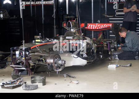 F1-Mechaniker bei der Arbeit auf einem McLaren Mercedes F1 Autos in der Boxengasse Werkstatt Silverstone Rennstrecke Stockfoto