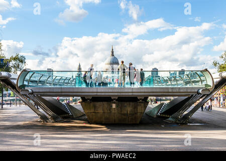 Touristische am Bankside Ende der Millennium Bridge, London, UK, die St Paul's Kathedrale im Hintergrund Stockfoto