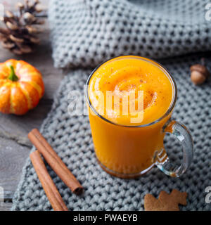 Kürbis Smoothie, Latte mit Gewürzen. Versoffenes Cocktail auf einer hölzernen Hintergrund. Nahaufnahme Stockfoto
