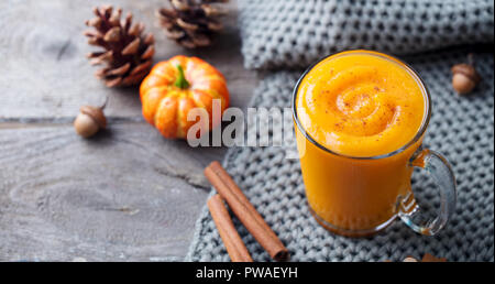 Kürbis Smoothie, Latte mit Gewürzen. Versoffenes Cocktail auf einer hölzernen Hintergrund. Platz kopieren Stockfoto
