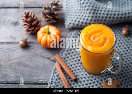 Kürbis Smoothie, Latte mit Gewürzen. Versoffenes Cocktail auf einer hölzernen Hintergrund. Nahaufnahme Stockfoto