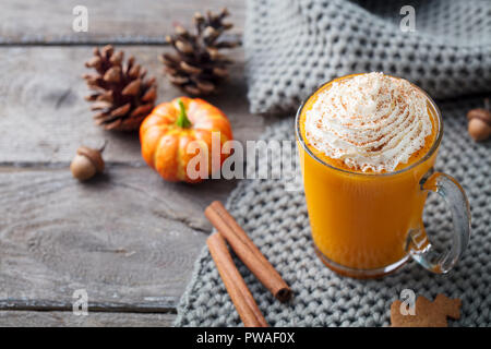 Kürbis Latte mit Gewürzen. Versoffenes Cocktail mit Schlagsahne. Holz- Hintergrund. Platz kopieren Stockfoto