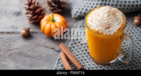 Kürbis Latte mit Gewürzen. Versoffenes Cocktail mit Schlagsahne. Holz- Hintergrund. Platz kopieren Stockfoto
