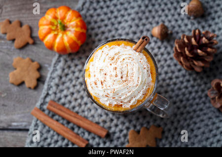 Kürbis Latte mit Gewürzen. Versoffenes Cocktail mit Schlagsahne. Grauer Hintergrund. Ansicht von oben Stockfoto